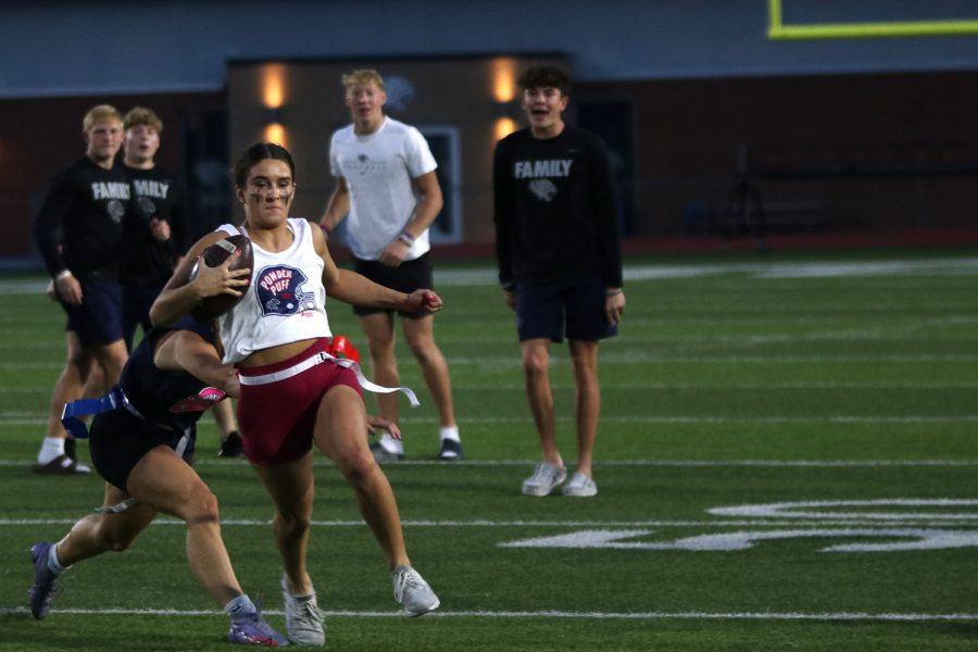 Ball in hand, junior Makenna Payne attempts to run the ball down the field and score. 