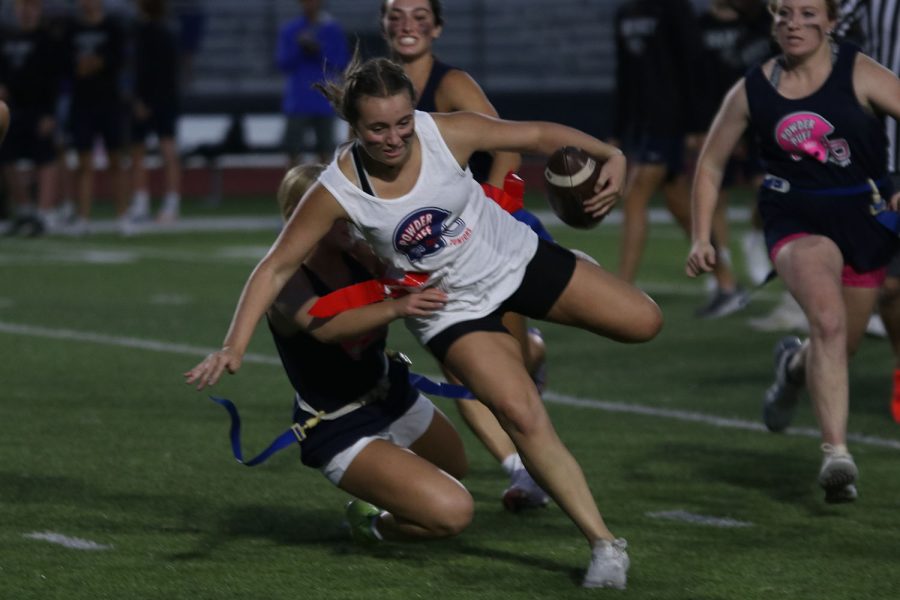 While getting her flag pulled, junior Elly VanRheen gets pulled to the ground by a member of the senior team. 
