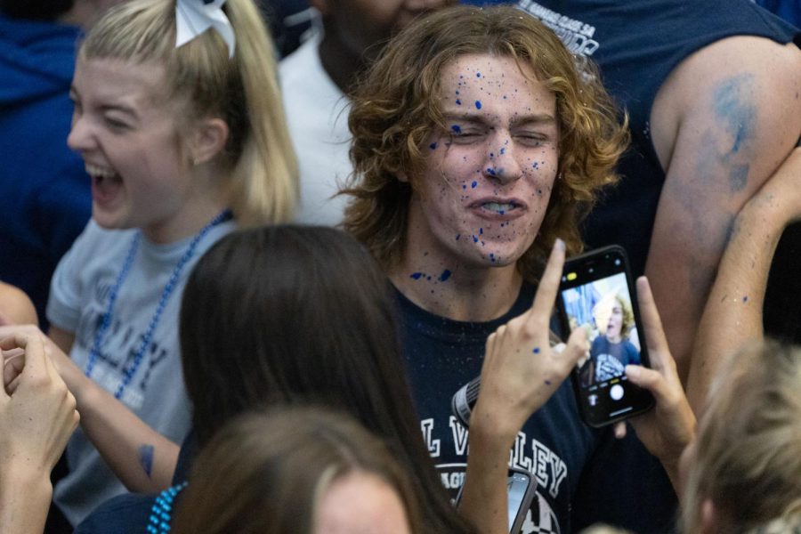 After a balloon filled with paint explodes in his face, senior Toby Kornis smiles for a picture with blue paint splattered all over. 