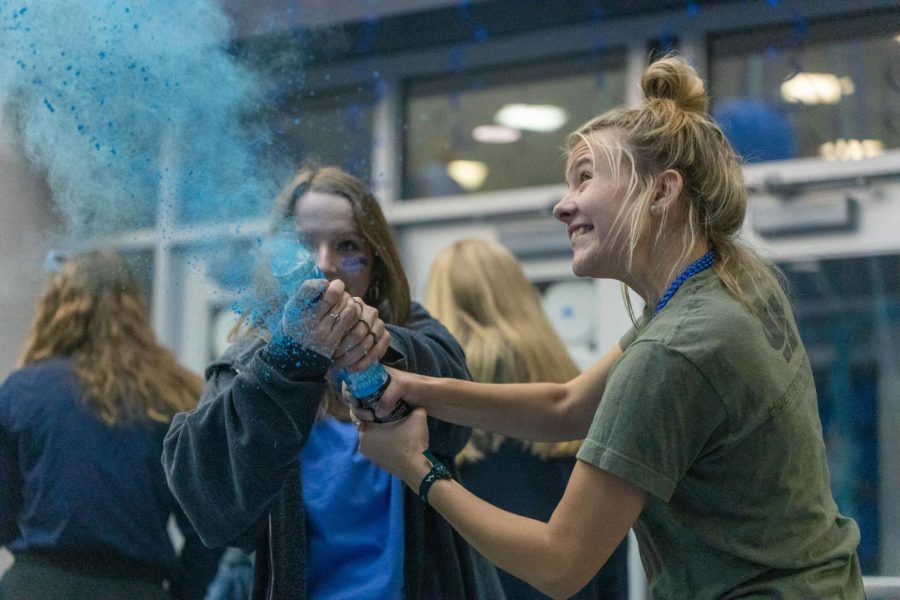 Spraying blue dust everywhere, senior Bella Mehner twists the exploding tube to release the blue powder.