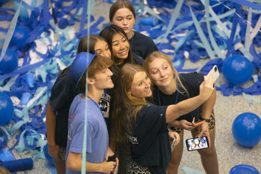 Holding the camera up high, senior Macy Moore poses for a picture alongside her friends. 
