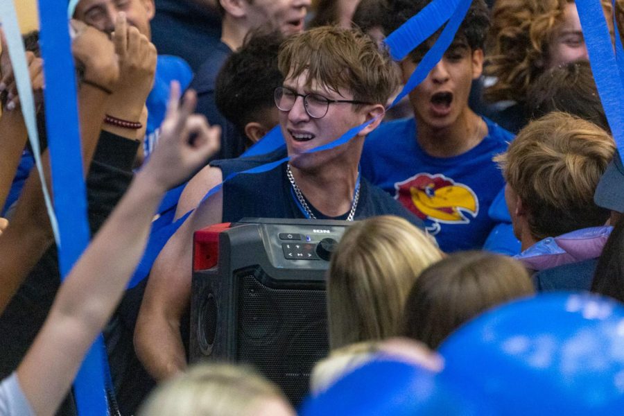 With the speaker in his hands, senior Max Weber sings along with the music.
