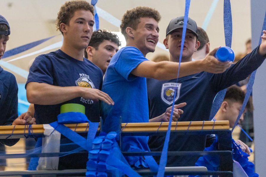 Making a plan, seniors Dylan Ashford and Colin Riley smile and point towards the jaguar statue in front of them.