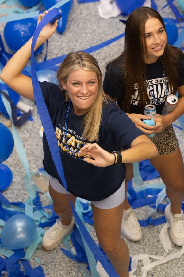 With blue streamers in hand, senior Dylan Dedrickson smiles and prepares to throw them.
