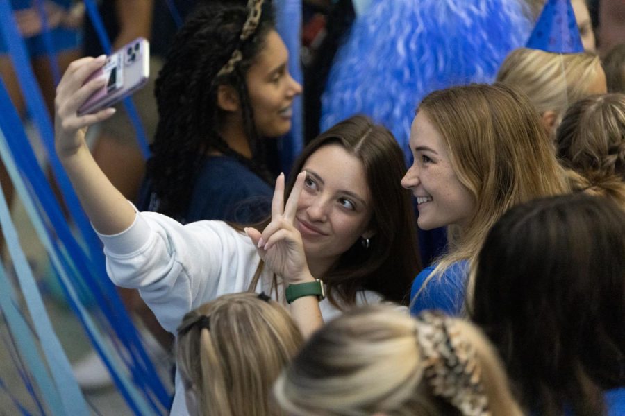 Taking a picture among the chaos, senior Libby Strathman smiles for the camera. 