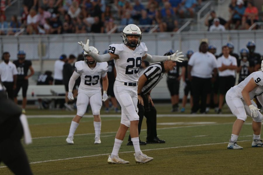 With arms wide open, senior Dylan Massey signals his fellow defensive players.