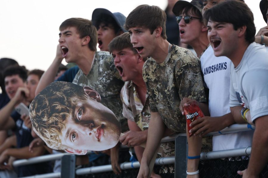 Standing in the student section, a group of seniors cheer on their friends on the field. 