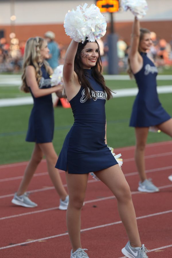 Waving her pom pom to the crowd, junior Keira Bret gets ready for the game to start. 