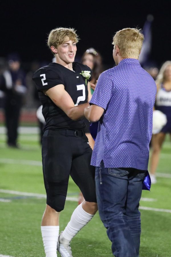 Senior Homecoming candidate Hayden Jay reaches his hand out to shake previous teammate and Homecoming king Cody Moore’s hand after receiving this years title as Homecoming king. 