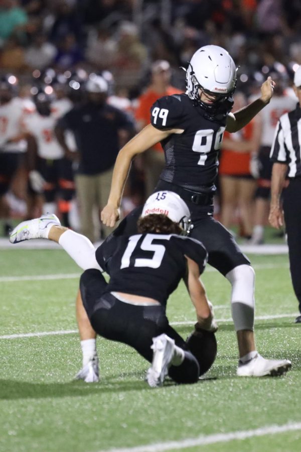 Preparing to kick the field goal, junior Kenton Laughman winds his leg up while junior Daniel Blaine holds the ball for him. 
