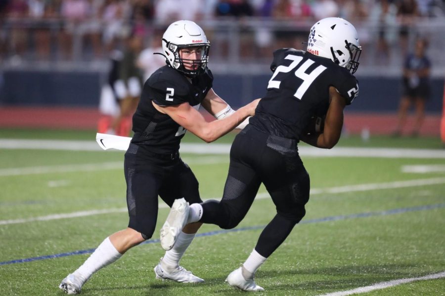  After receiving the snap, senior quarterback Hayden Jay hands the ball off to senior running back Amarian Graves. 

