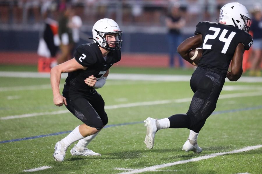 In an attempt to trick the opposing team, senior Hayden Jay runs the other way after handing the ball to senior running back Amarian Graves. 