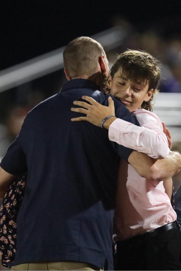 Hugging his dad, senior Homecoming candidate Eli Olson gets ready for the big moment. 