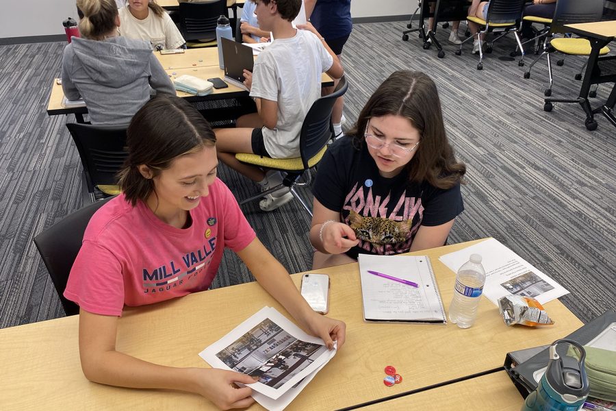 Smiling at a photo, senior Lauren Aycock helps students with photography skills. 