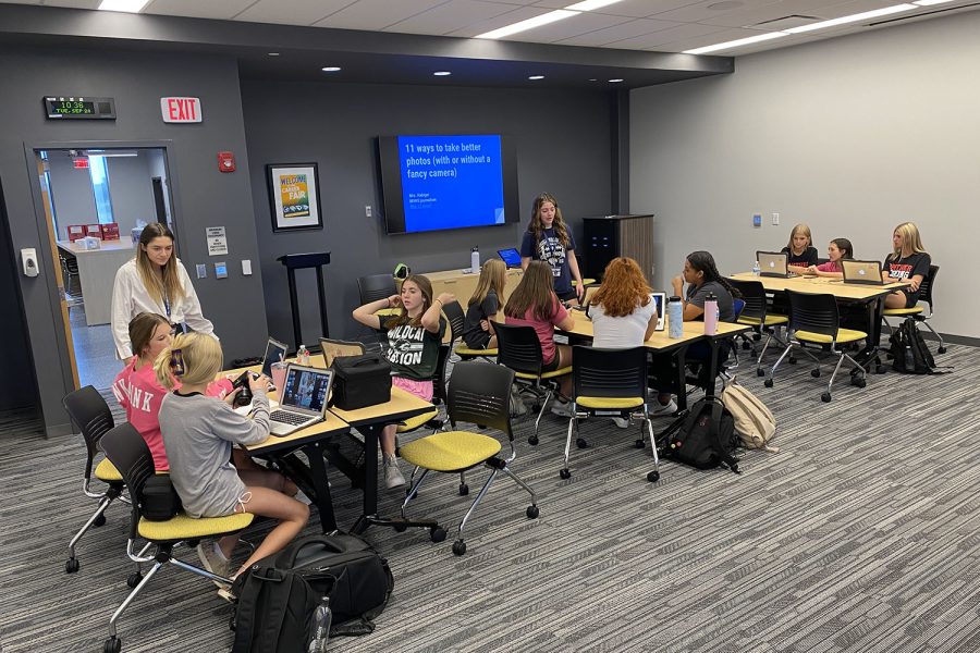 Students gather in a room to go over how to take photos.