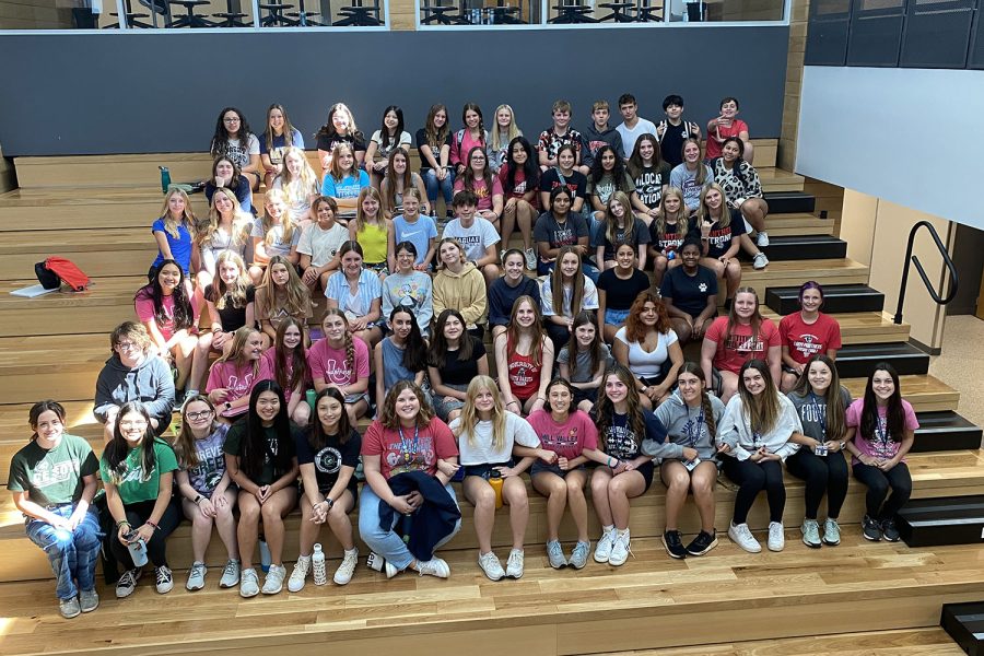 Smiling at the camera, middle and high school students gather together for a final picture. 