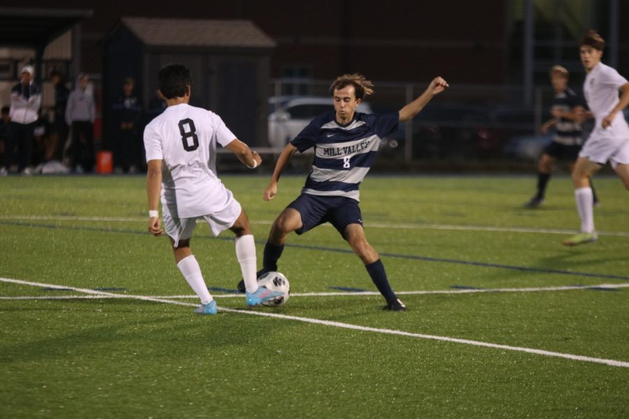 Senior Jack Gilmore blocks a pass from a Lawrence Free State midfielder.