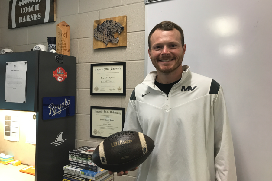 Happy to be teaching in the school, Joshua Barnes holds up a football from the state championship game on Thursday, September 1. “It’s just something that I have in my office, just as a reminder of how special the season was” Barnes said, “I just like to keep it there on display”. 