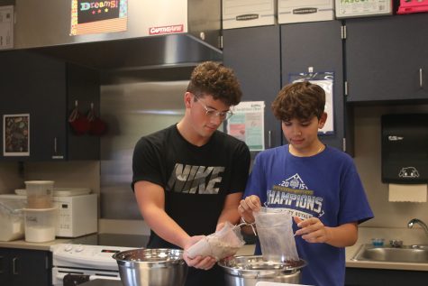 Pouring brownie mix into a bowl, juniors Ethan Brownfield and Corbin Garnand get ready to make desserts.
