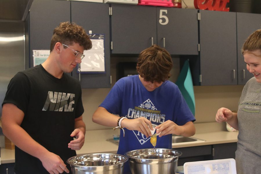 Cracking an egg, juniors Ethan Browfield, Corbin Garnand and senior Casey Cunningham follow directions to bake brownies. 
