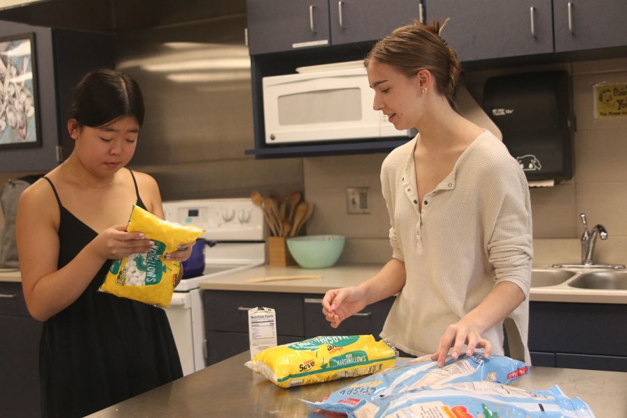 Reading the instructions, seniors Ally Sul and Ashlyn Elliott prepare to make Rice Krispie Treats.