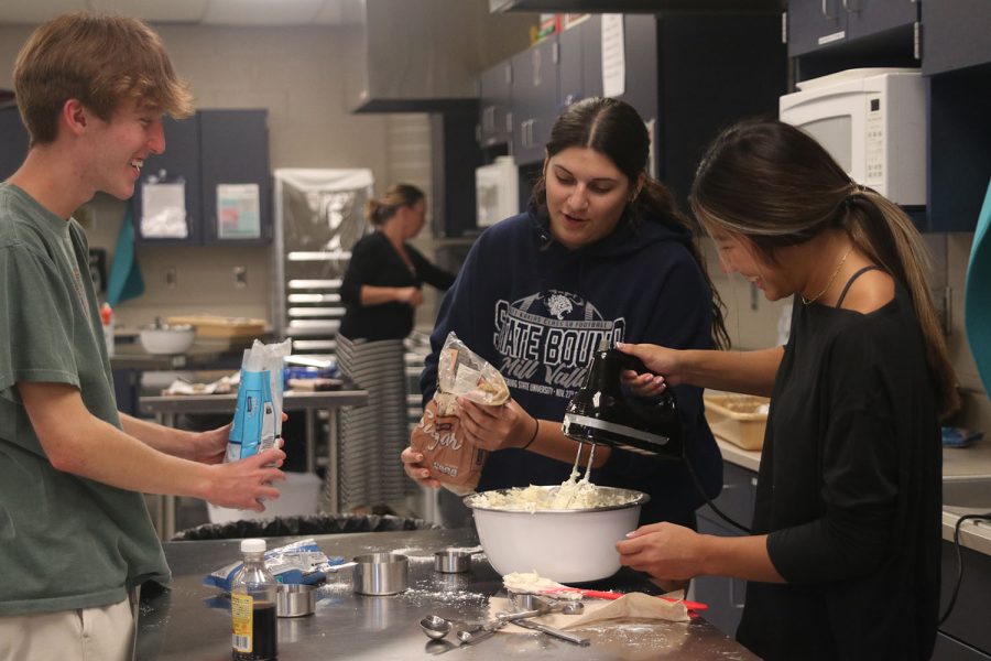 Mixing the cookie dough dip, seniors Sonny Pentola, Torri Olivarez and Amaiya Manirad get ready to add in the next ingredients.