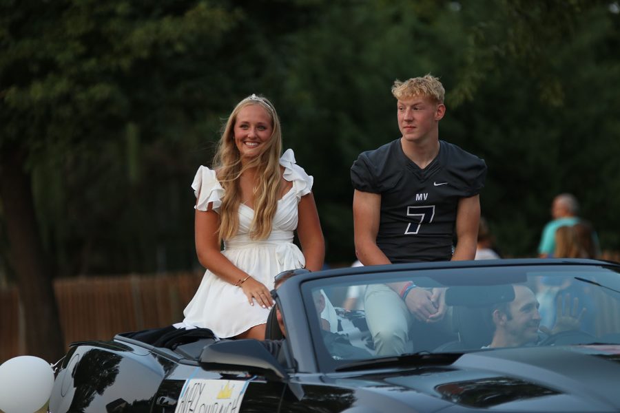 Listening to the crowd cheer, senior Homecoming candidates Avery Blubaugh and Mikey Bergeron happily ride their float. 