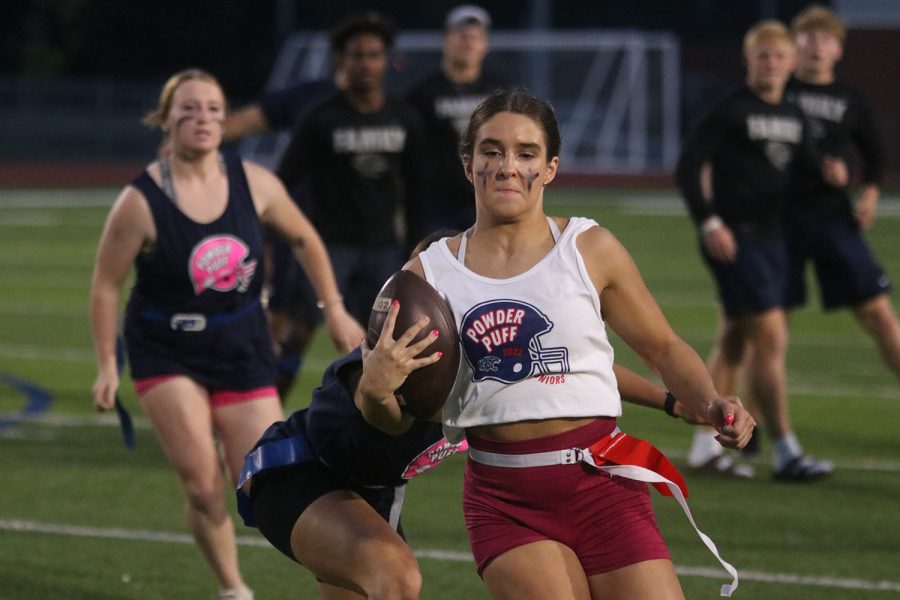 Running up the field, with the ball in her hand, junior Makenna Payne attempts to score.