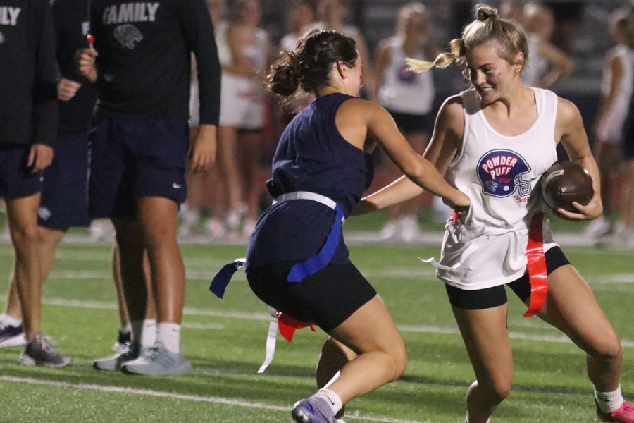 Running the ball, junior Kate Ricker faces off with senior Gracie Knight to get into the end zone.