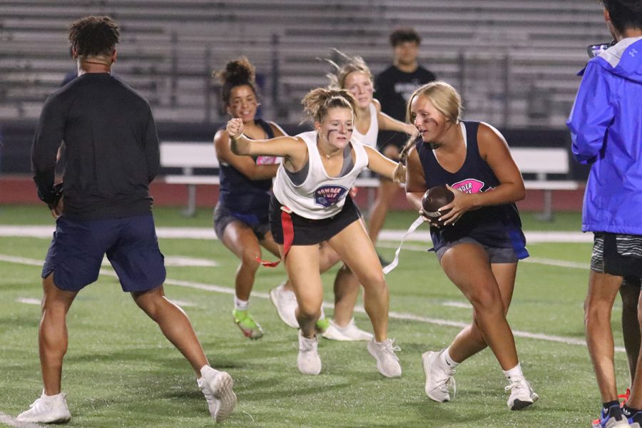 Going on for the grab, junior Lucy Roy attempts to pull the flag off of senior Avery Blubaugh with the ball in hand.
