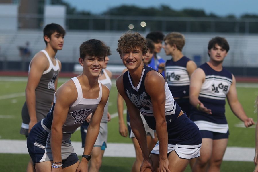Seniors Lucas Robins and Ethan Sutton pose for a photo in their cheerleading uniforms.