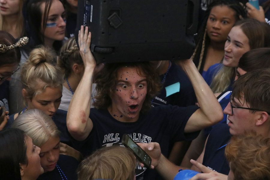 With blue paint splattered over his face, senior Toby Kornis jumps around to the beat of the music.