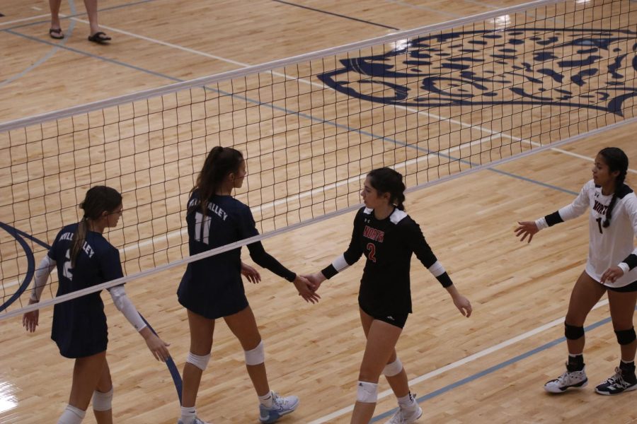 After defeating Shawnee Mission North in two sets, the girls volleyball team shakes hands with their opponent.  