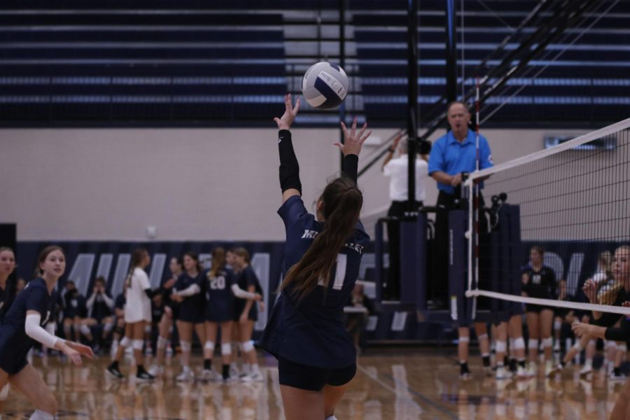 Hands in the air, freshman Ella Florez sets her teammates up for the point. 