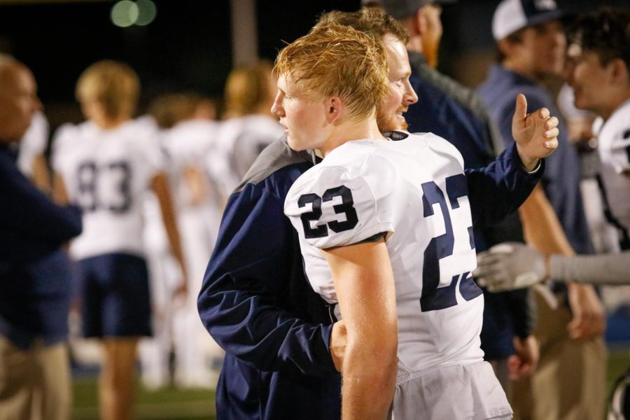 Coach Joshua Barnes congratulates senior Holden Zigmant on a great game.