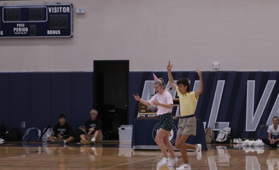 Hands in the air, senior Homecoming candidates Eli Olson and Jenna Myres run on the floor as they are introduced.
