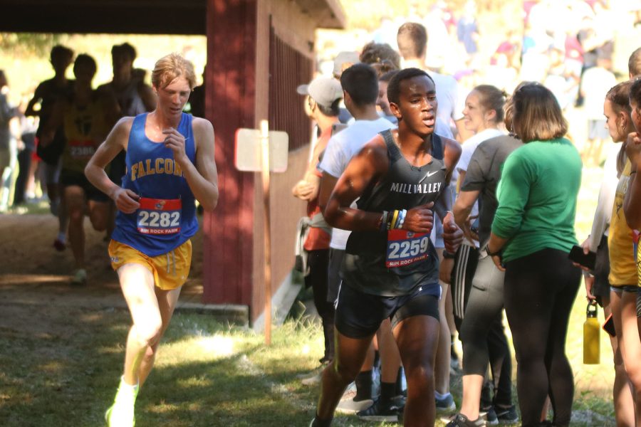 On the last mile of the 5K, junior AJ Vega passes a runner on after running through Kings Bridge.