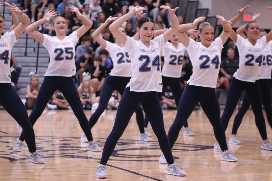 With her hands in the air, junior Keira Bret poses during the Silver Stars dance. 