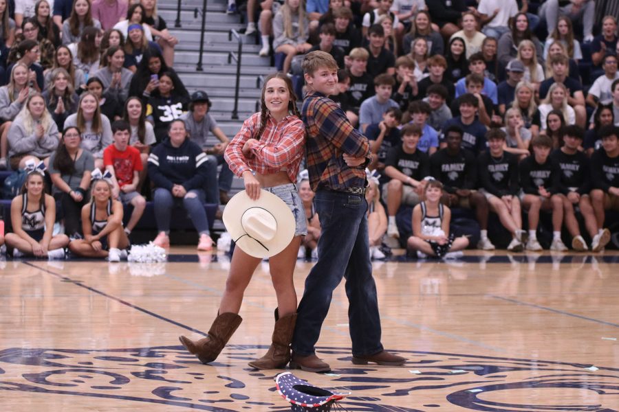 Following their dance to “Cotton Eye Joe”, senior Homecoming candidates Laney Reishus and Brody Shulda pose with their cowboy hats in front of the judges table.