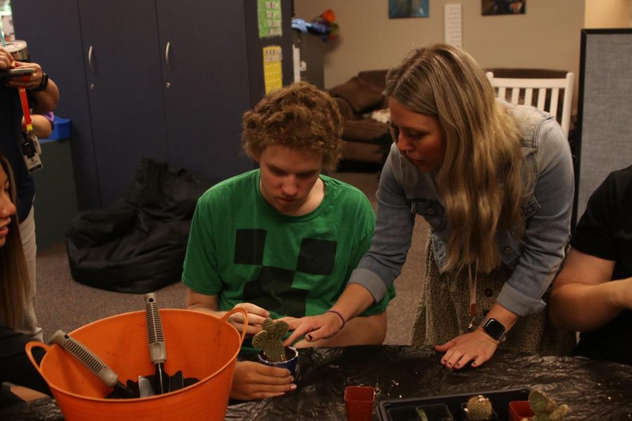 Special education teacher Kaila Masters helps senior Vash Jobe place a cactus in a pot Tuesday, Sept 27.