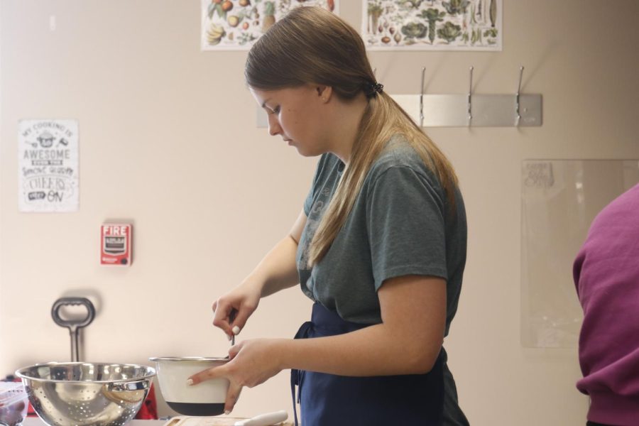 Stirring the ingredients together, junior Ashlyn Bellmyer makes fruit salsa. 