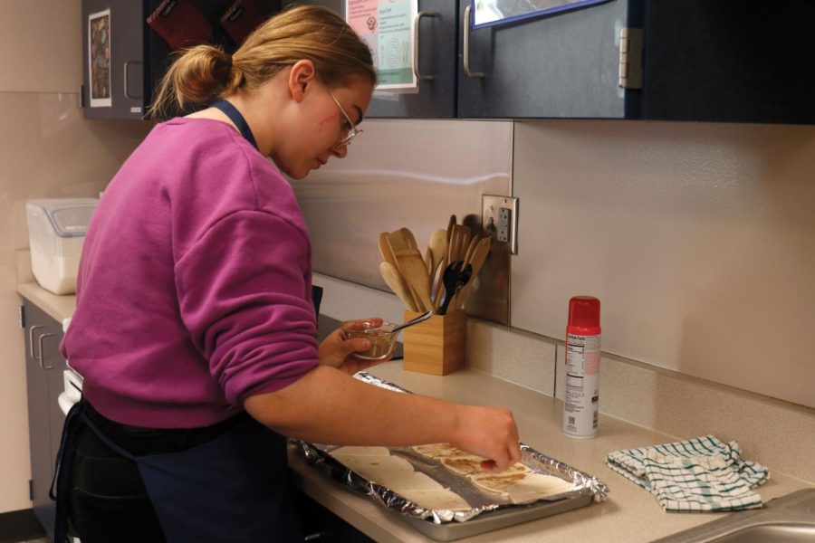 Sprinkling cinnamon over her tortillas, sophomore Lillian Schleicher gets them ready to put in the oven.  