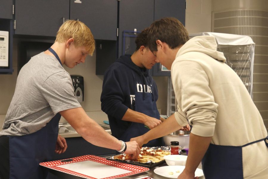 Seniors Holden Zigmant and Nick Ravnsborg work together to put the finishing touches on the pieces of bread. 