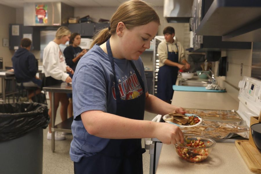 Ready to try her finished product, sophomore Alyssa Hogg scoops the fruit salsa onto her plate.
