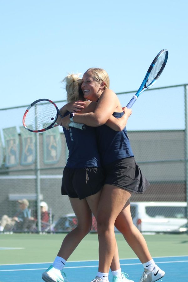 Seniors Skylar Szoke and Avery Blubaugh hug in celebration after securing a spot at state.