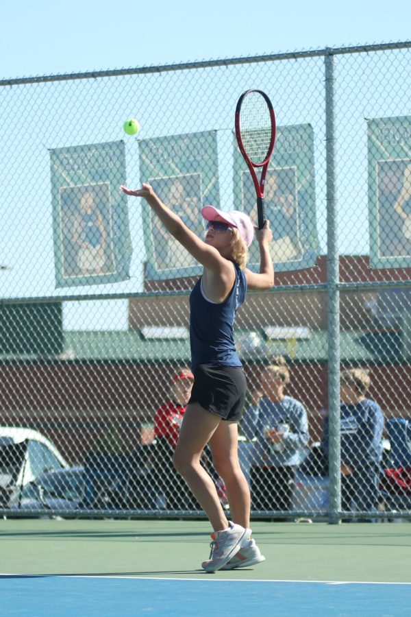 Preparing to serve to her opponent, freshman Heidi Baillos tosses the ball up in the air.