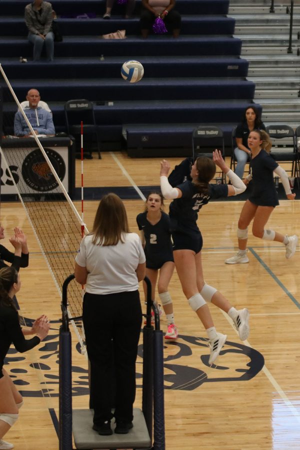 In the air, sophomore Saida Jacobs prepares to hit the ball to the other side of the court. 