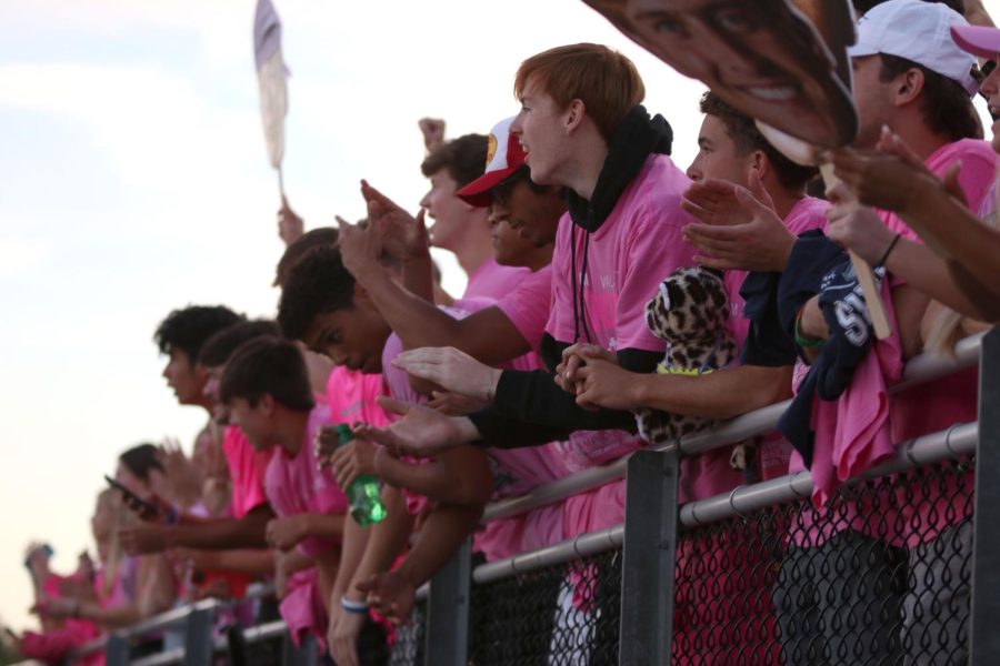The seniors at the front of the student section cheer on the team as they run out.