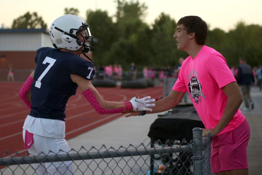 Senior Mikey Bergeron runs out before the game and shakes hands with senior Marko Skavo.