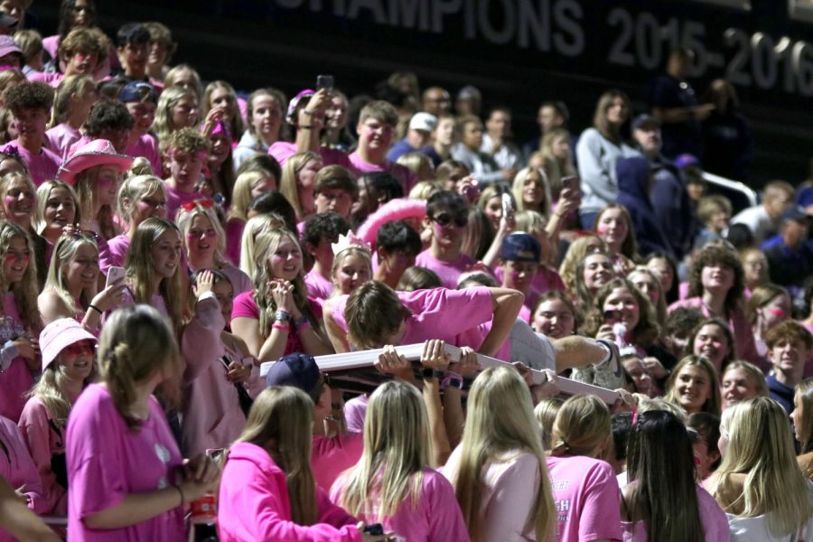 The Student sections cheers on senior Toby Kornis as he does pushups on the board.